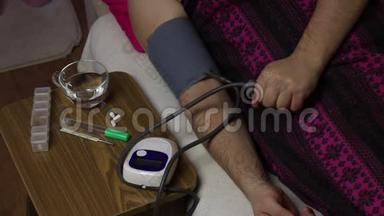 那个<strong>病人躺在</strong>一张铺着毯子的<strong>床上</strong>。 用血压监测仪测量血压。 他拿走了那个装置